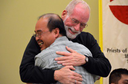 Fr. Ed gives Fr. Quang a congratulatory hug after Fr. Quang's election to council