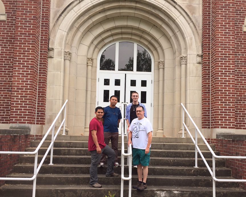 Fr. Patrick, Fr. Joseph, Frater Justin and Fr. Wayne on the steps of the old Mission House in Ste. Marie