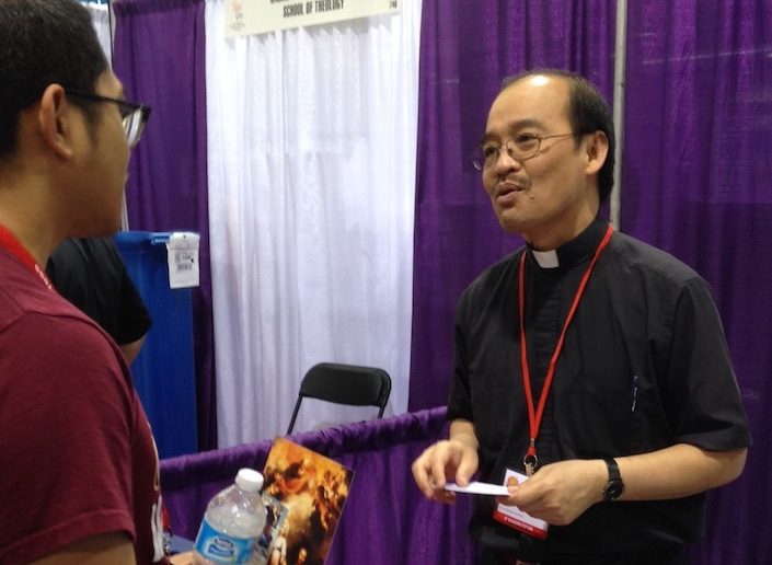 Fr. Quang Nguyen staffing the SCJ vocation booth at youth gathering