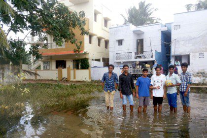 Members of the formation community in Chennai stand in the flooded streets near their home. 