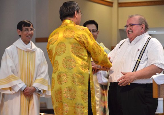 Fr. Yvon receives a gift from the Vietnamese community