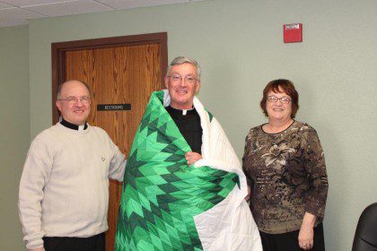 Fr. Tom Cassidy (center) receives a quilt from the board of directors of St. Joseph's Indian School. They commemorated his time with the board as provincial superior. A new administration will be elected in June.