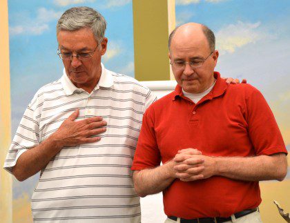 Fr. Tom Cassidy (left) and Fr. Stephen Huffstetter stand together in prayer following Fr. Steve's acceptance of the  elation.