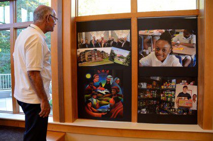 Fr. Richard Woodbury looks at photos depicting SCJ ministry in North America. The photos were brought in during the opening ritual of the conference and on display throughout the week. 