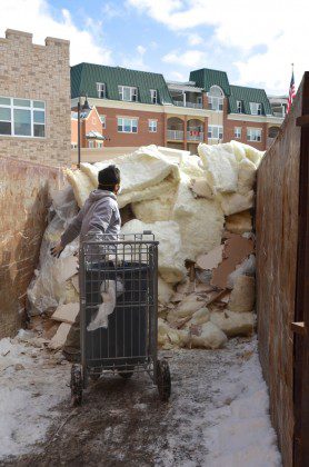 A worker empties another load of saturated insulation.