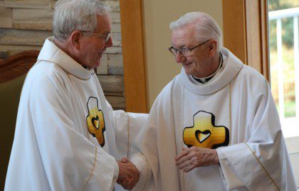Fr. Jan and Fr. Mike Burke share the Sign of Peace during Fr. Jan's jubilee Mass on Sunday.