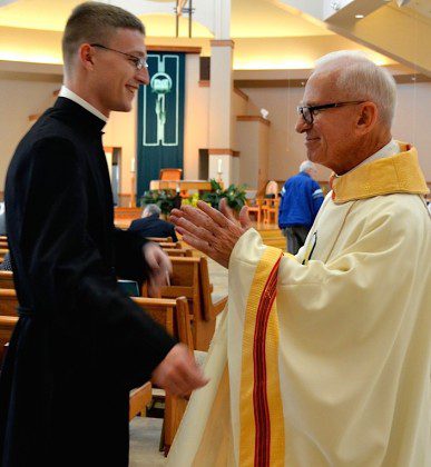 Fr. John (right) wishes Justin good luck prior to Justin's first profession ceremony last week. 