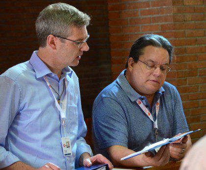 Fr. Heiner shares a hymnal with Fr. Jack Kurps during prayer prior to the elections